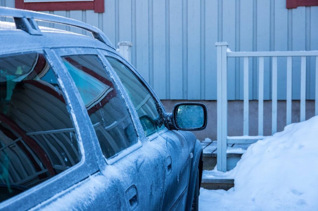 volvo parkerad utanför ett hus och en snödriva